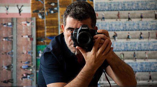 Fotograf Xan Padron drži kamero pred umetniškim delom